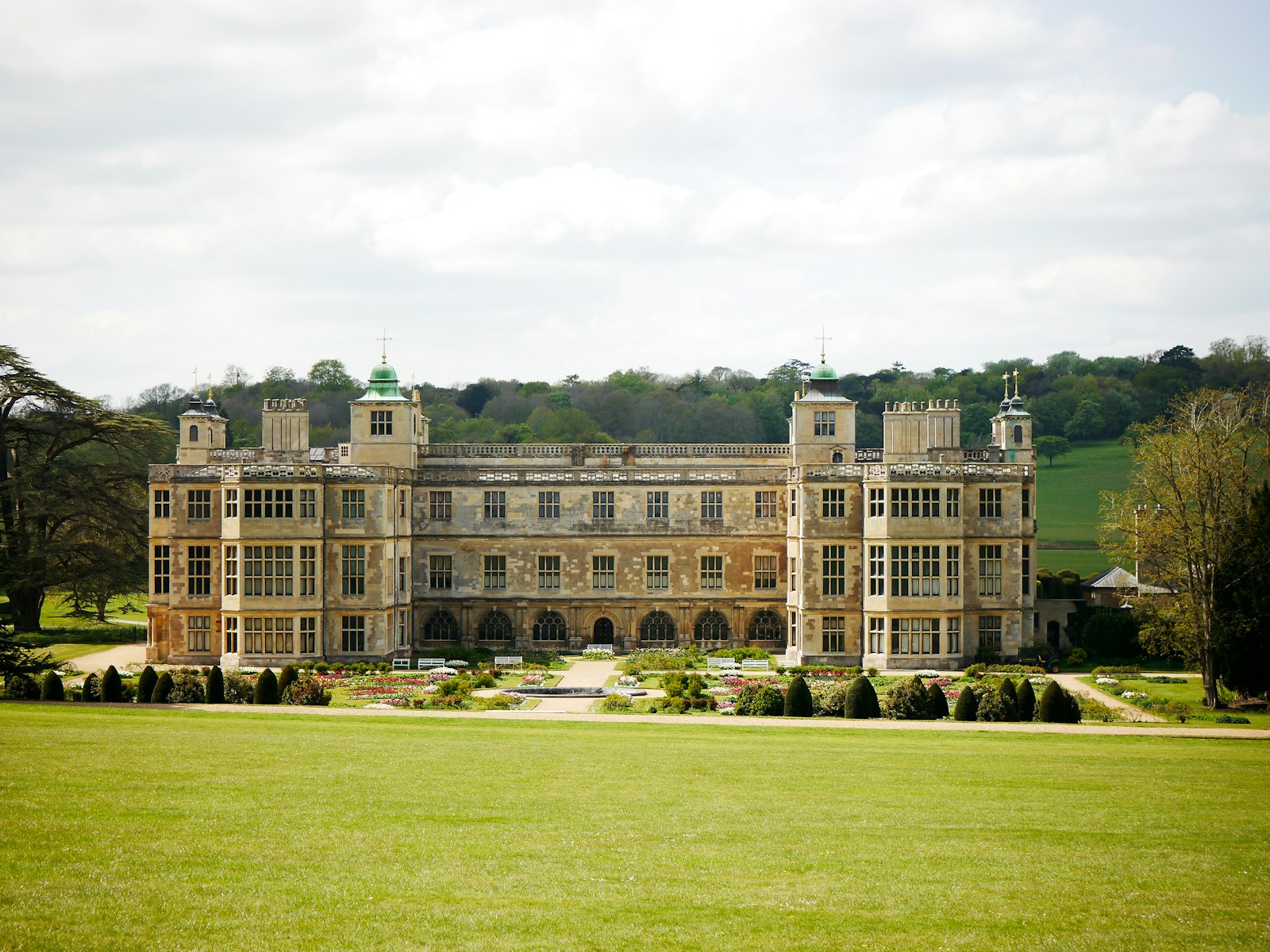 Grand historic manor house with lawn and distant trees at Audley End, England.