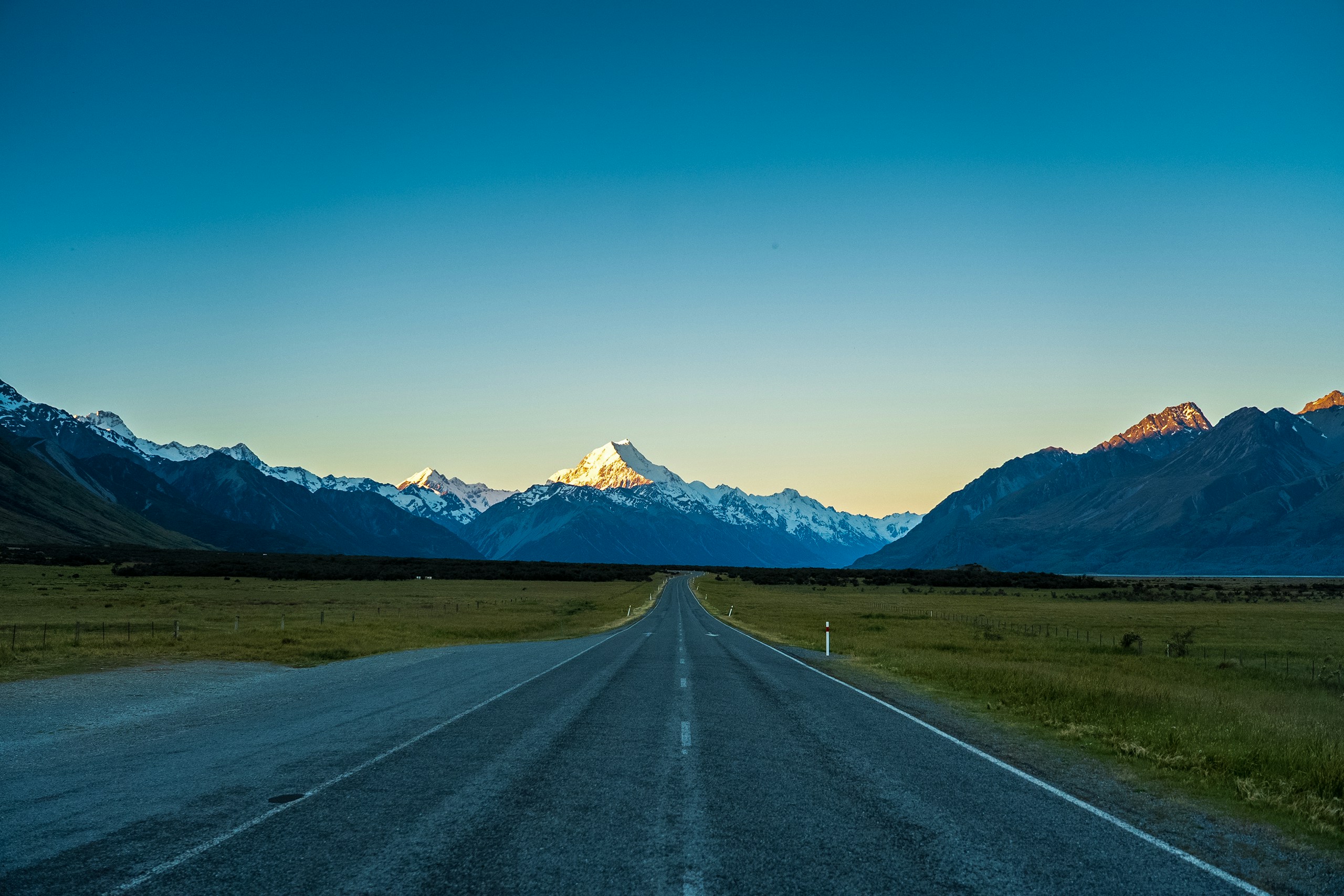 Road leading toward snow-capped mountains in Canterbury, New Zealand
