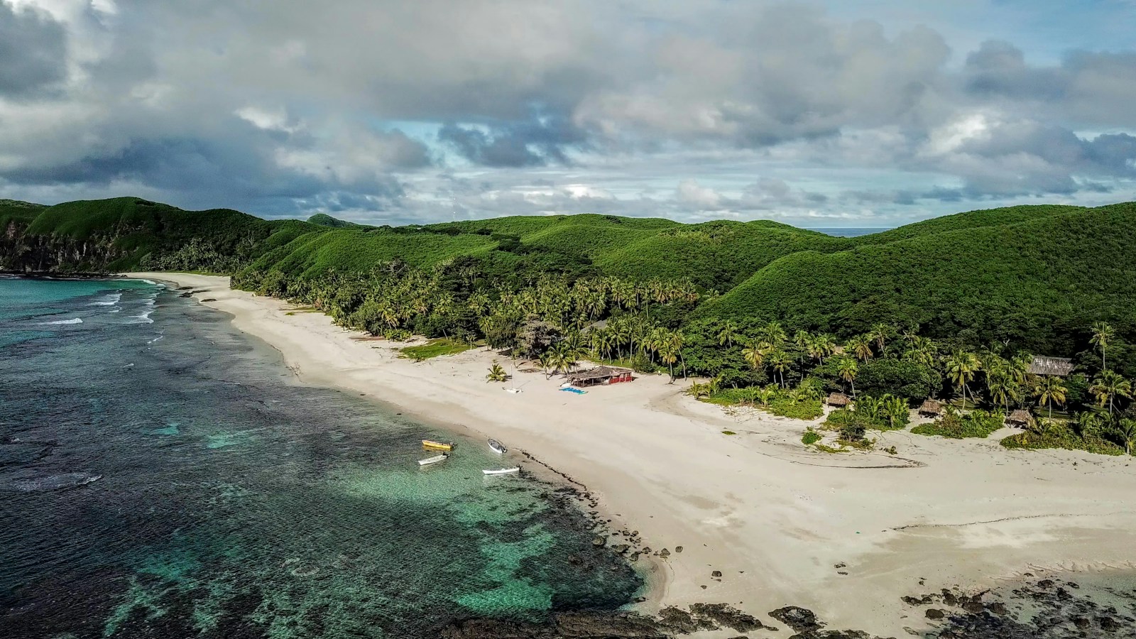 A beach and green hillside on Yasawa Island, Fiji.